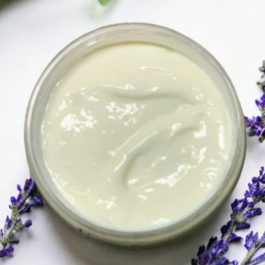 A jar showing the creamy texture of the body butter