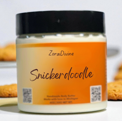 Jar of ZoraiDivine Snickerdoodle body butter with cookies in the background