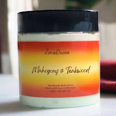 Jar of ZoraiDivine Mahogany & Teakwood body butter on a white surface with a blurred background