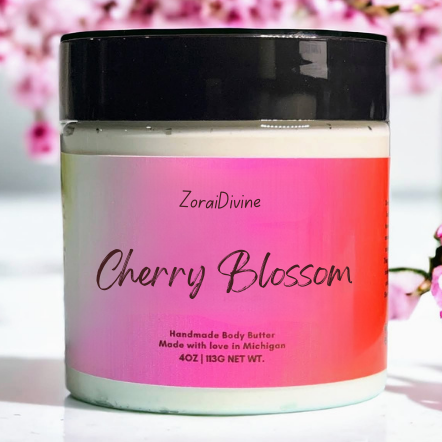 Jar of ZoralDivine Cherry Blossom body butter with cherry blossom flowers in the background.