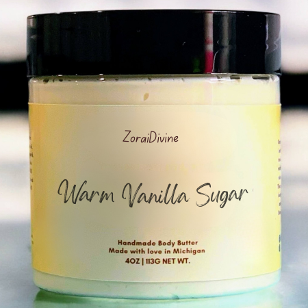 Jar of ZoraiDivine Warm Vanilla Sugar handmade body butter on a reflective surface.