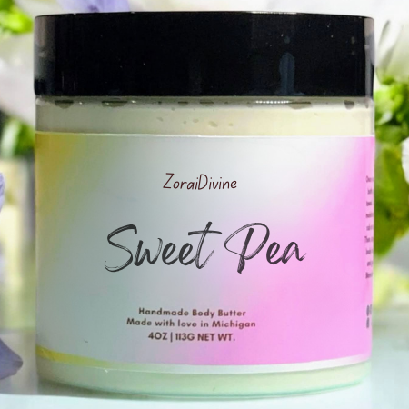 Jar of ZoraiDivine Sweet Pea body butter with a black lid on a blurred background