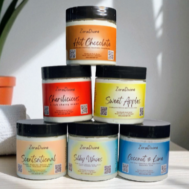 Stack of ZoraiDivine body butters with colorful labels on a light surface.