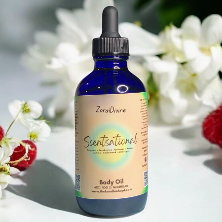 ZoraiDivine Scentsational Body Oil bottle with a dropper on a white background with flowers.