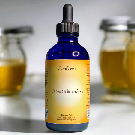 Bottle of ZoraiDivine Almond milk & honey body oil with a dropper on a blurred background