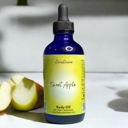 Bottle of ZoraiDivine Sweet Apple body oil with a yellow label on a white surface.