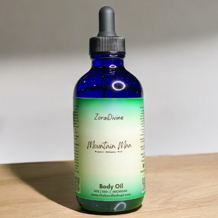 Bottle of ZoraiDivine Mountain Man Body Oil on a wooden surface with a neutral background