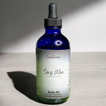 Bottle of ZoraiDivine Sexy Man Body Oil on a wooden surface with a neutral background