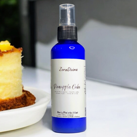 Body mist Pineapple cake on a white background with pineapple cake around the bottle.