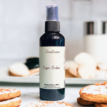 Body mist Spray bottle Sugar cookies with cookies around the bottle on a white surface
