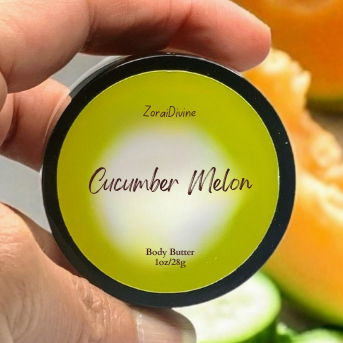 Cucumber Melon body butter container held by a hand with a blurred background