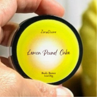 Lemon Pound Cake body butter container held by a hand with a blurred background