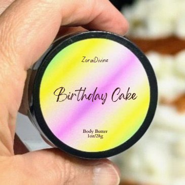 Hand holding a container labeled 'Birthday Cake' body butter with a colorful lid.
