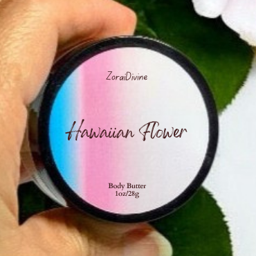 Hand holding a container of 'Hawaiian Flower' body butter with a flower in the background