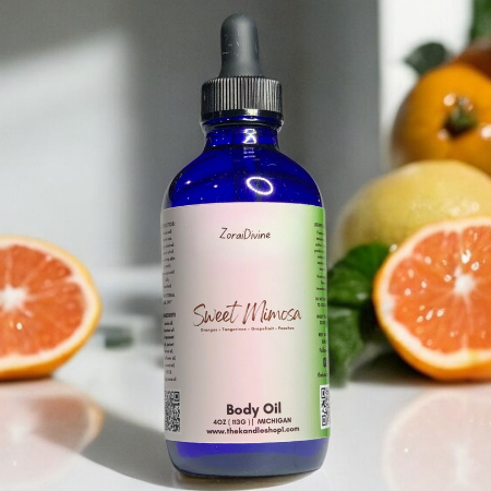 Bottle of Sweet Mimosa body oil with orange & grapefruit slices in the background
