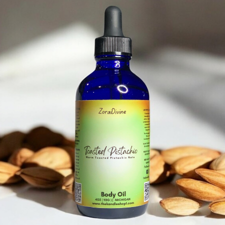 Bottle of ZoraiDivine Toasted Pistachio  body oil with almonds on a light surface