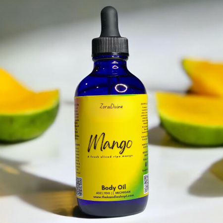 Bottle of Mango body oil with sliced mangoes on a white background
