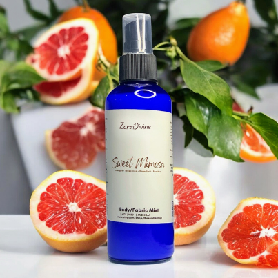 Body mist 'Sweet Mimosa' with citrus fruits in the background