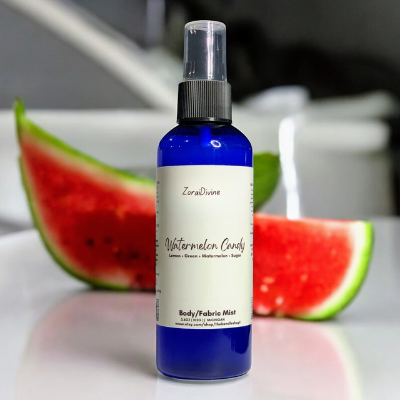 Body mist Watermelon candy on a white counter with watermelon slices on the background.