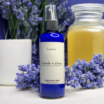 Body mist Lavender & Honey on a white countertop with lavender flowers & honey jar on the background.