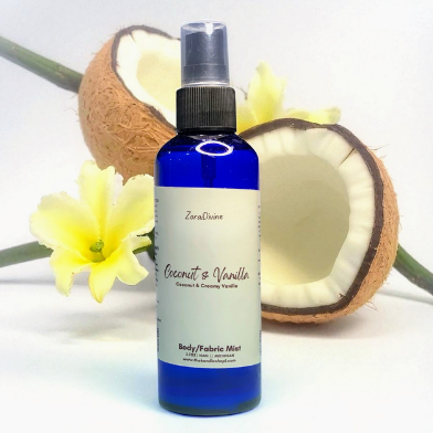 Body mist Coconut & vanilla on a white countertop with slices of coconut on the background.