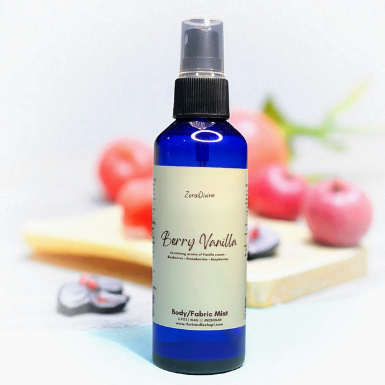Body mist Berry Vanilla on a white countertop with berries on the background.