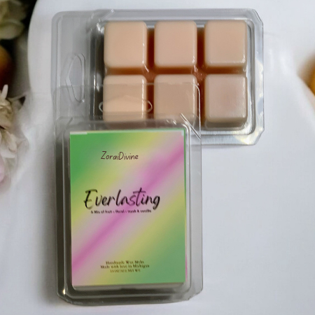 Wax melts packaging with a colorful label on a white surface with flowers and fruits.