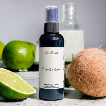 Body mist Coconut & Lime with limes and a coconut on a white surface.