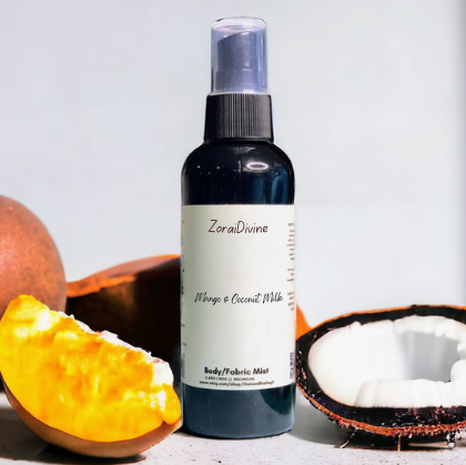 Body mist Mango & coconut milk on a white background with mangoes & coconuts around the bottle