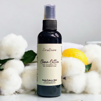 Body mist clean cotton on a white surface with lemons & cotton around the bottle