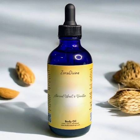 Blue bottle of Almond Wheat & Vanilla body oil with almonds on a light background