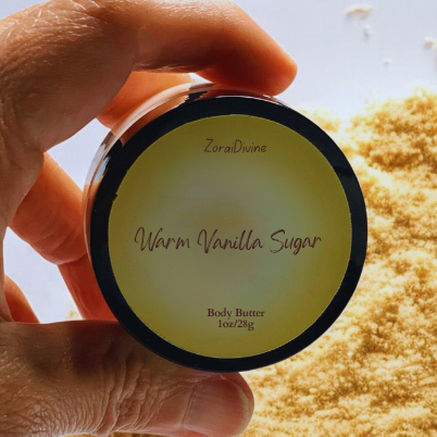 Hand holding a container of 'Warm Vanilla Sugar' body butter with visible brand name.