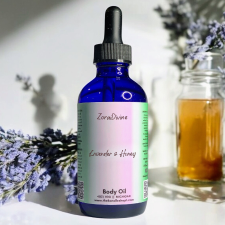 Bottle of ZoraiDivine lavender and honey body oil with lavender flowers & honey jar in the background